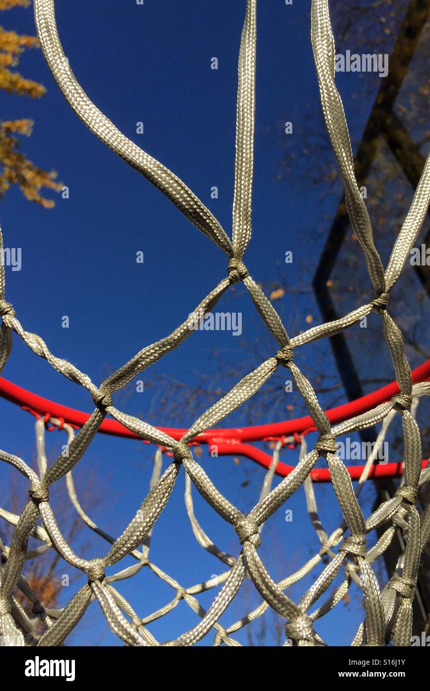 Looking through basketball hoop on a brilliant autumn day - Smartphone Captured Stock Image