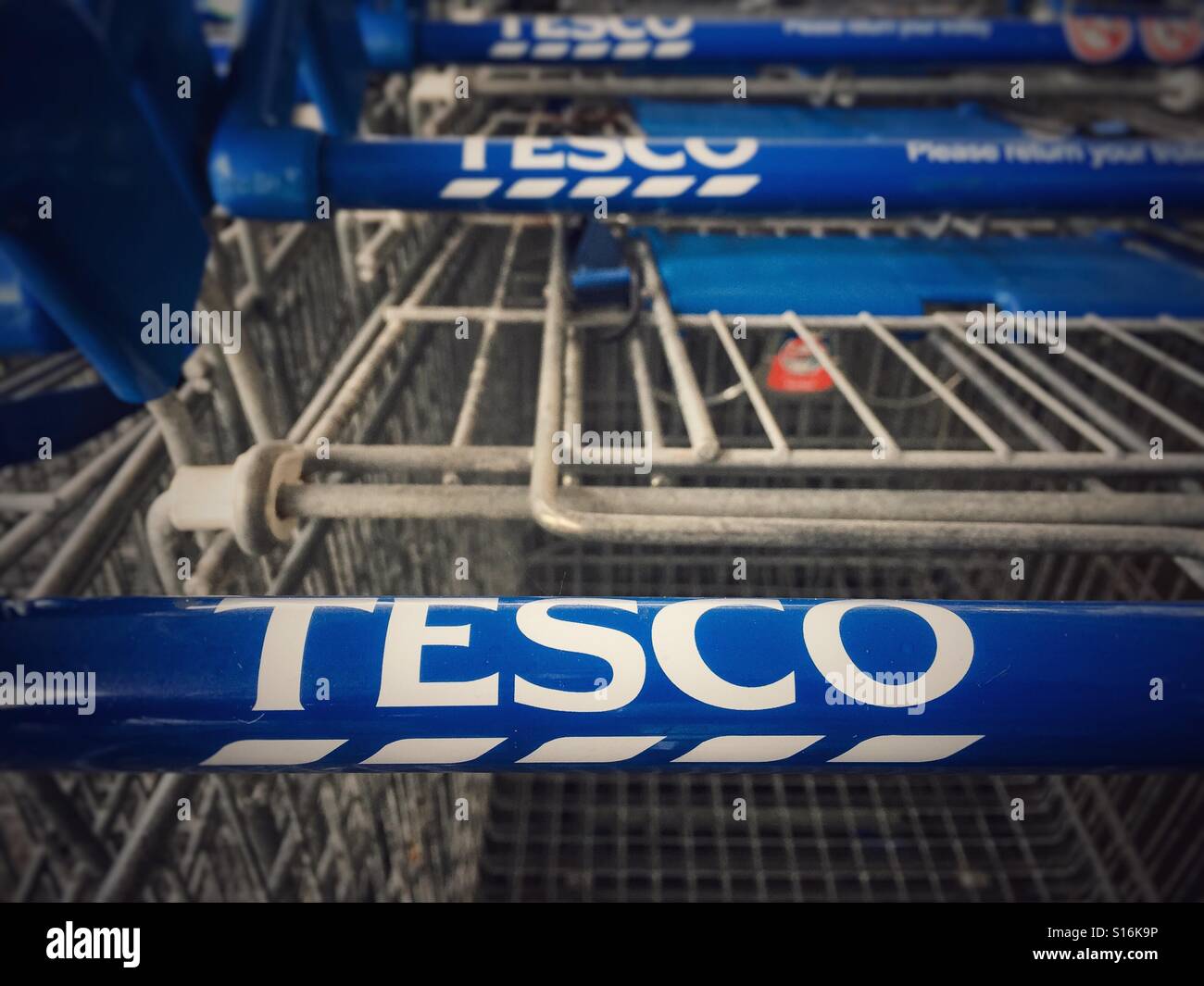 A row of Supermarket, Tesco, trolleys clearly showing the Tesco brand name  on the trolley handles Stock Photo - Alamy