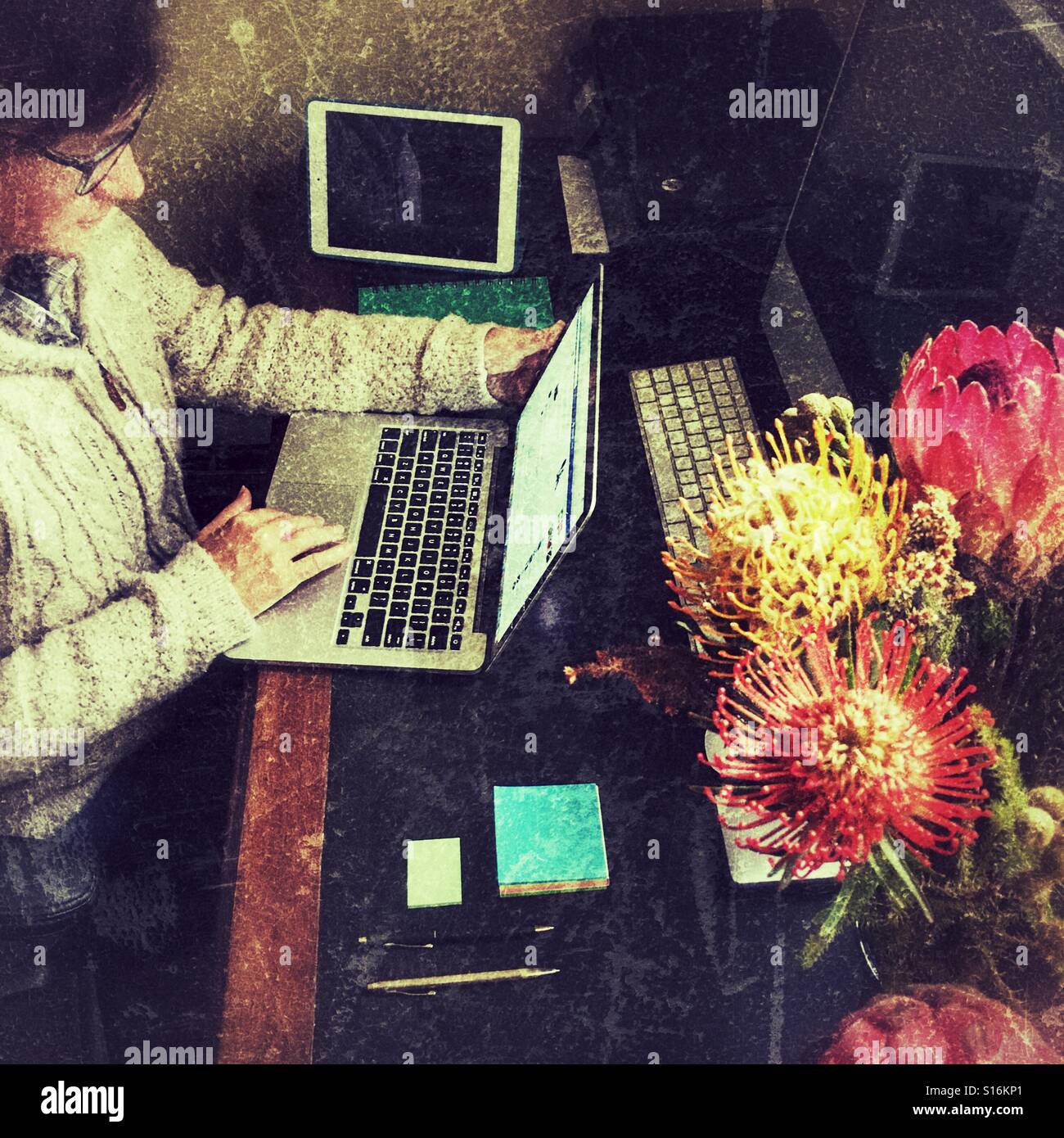 Woman at her desk , using laptop - Smartphone Captured Stock Image