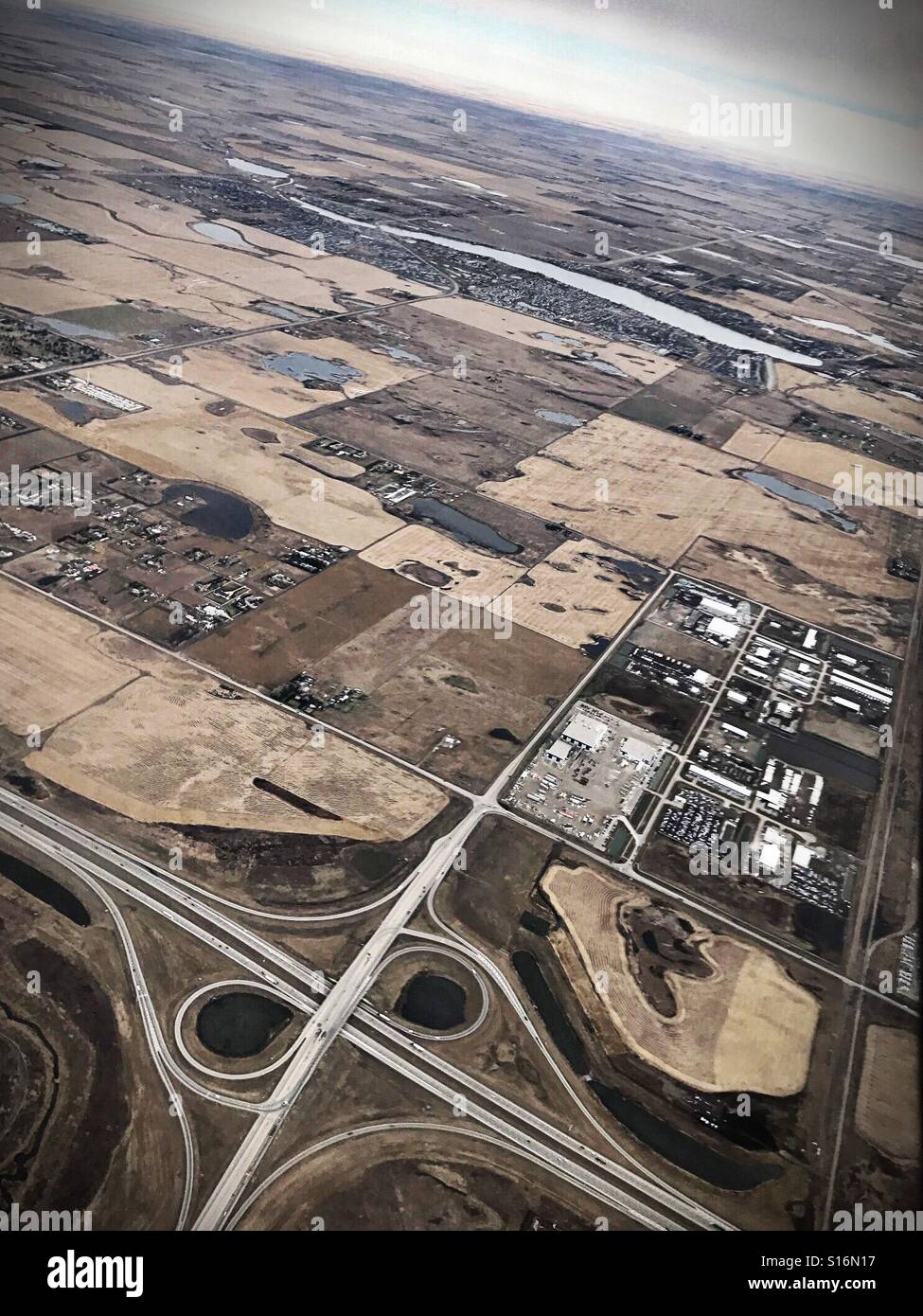 The lakeside city of Chestermere, seen from the air above a highway interchange in Calgary, Alberta, Canada. - Smartphone Captured Stock Image