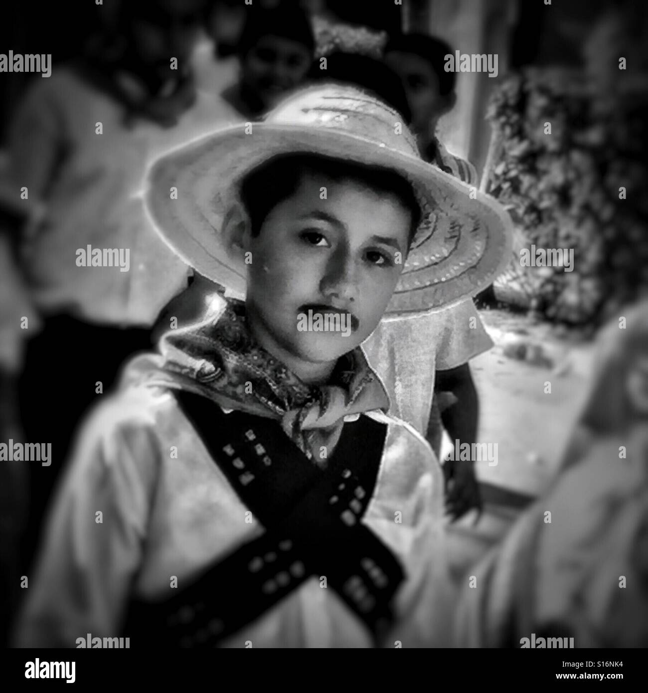 A boy with a painted on mustache participates in a parade celebrating Mexico's Revolution Day. Stock Photo