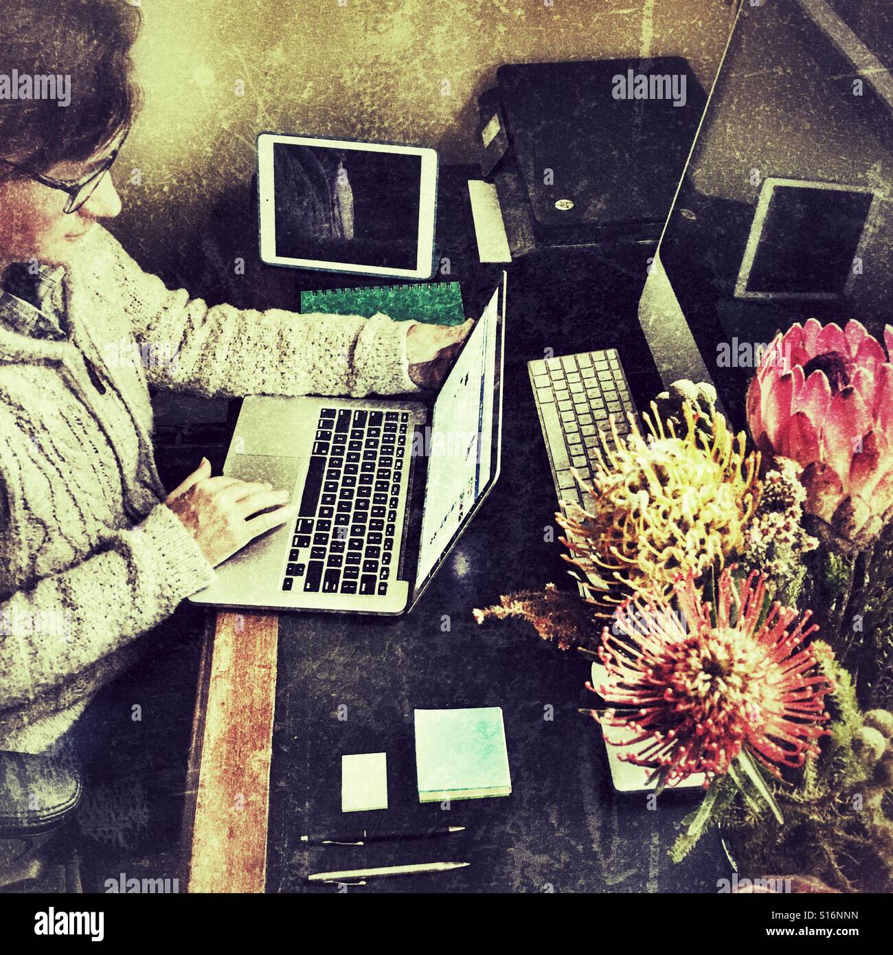 Woman at her desk, working on a laptop computer - Smartphone Captured Stock Image