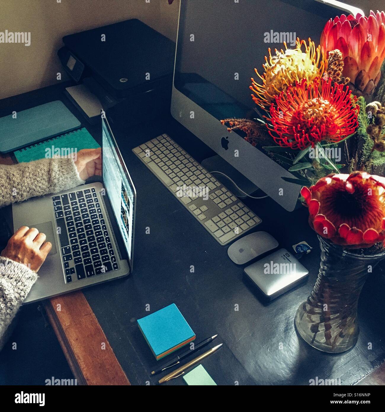Personal workspace, woman working on laptop - Smartphone Captured Stock Image
