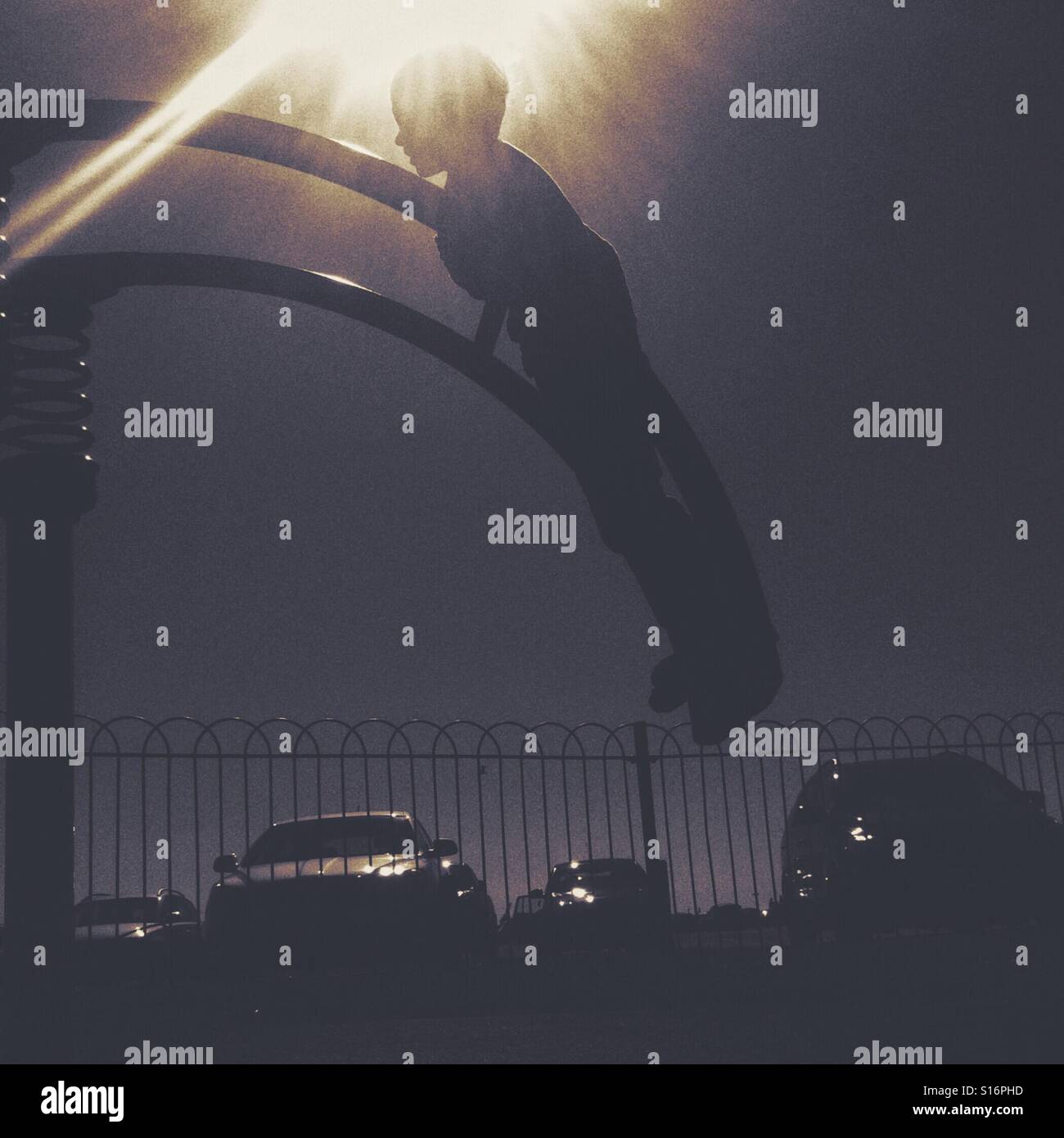 Child playing on exercise equipment as the sun goes down - Smartphone Captured Stock Image