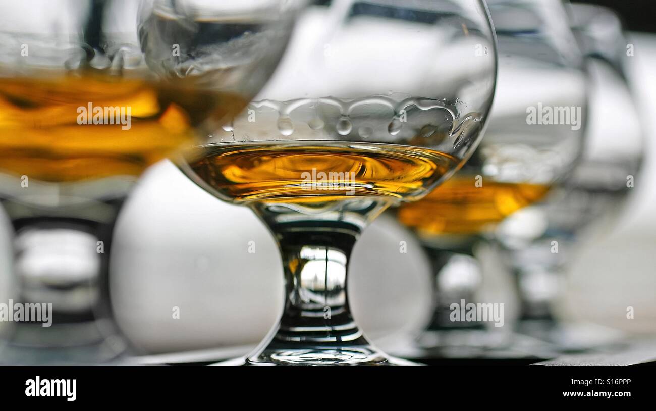 Whiskey is seen in stemware on a bar - Smartphone Captured Stock Image