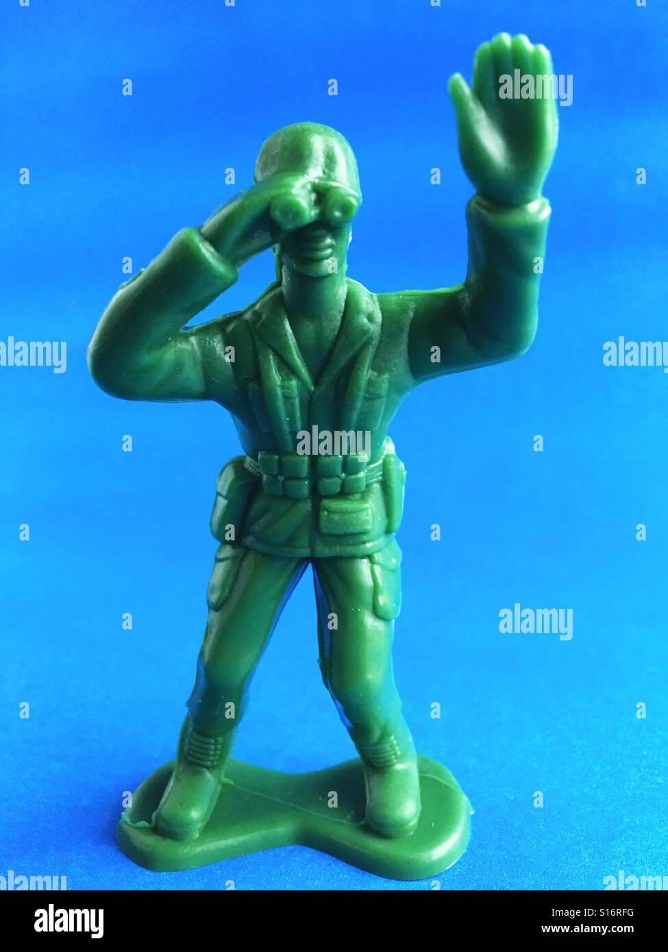 A toy soldier looking through binoculars. Stock Photo