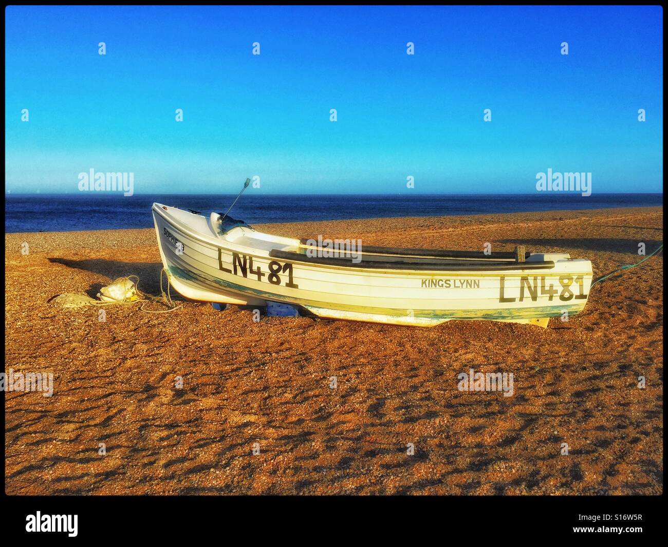 An abandoned boat on the beach in Blakeney National Nature Reserve, near Cley next the Sea in Norfolk, England, UK. The sea on the horizon is The North Sea. Photo Credit - © COLIN HOSKINS. - Smartphone Captured Stock Image