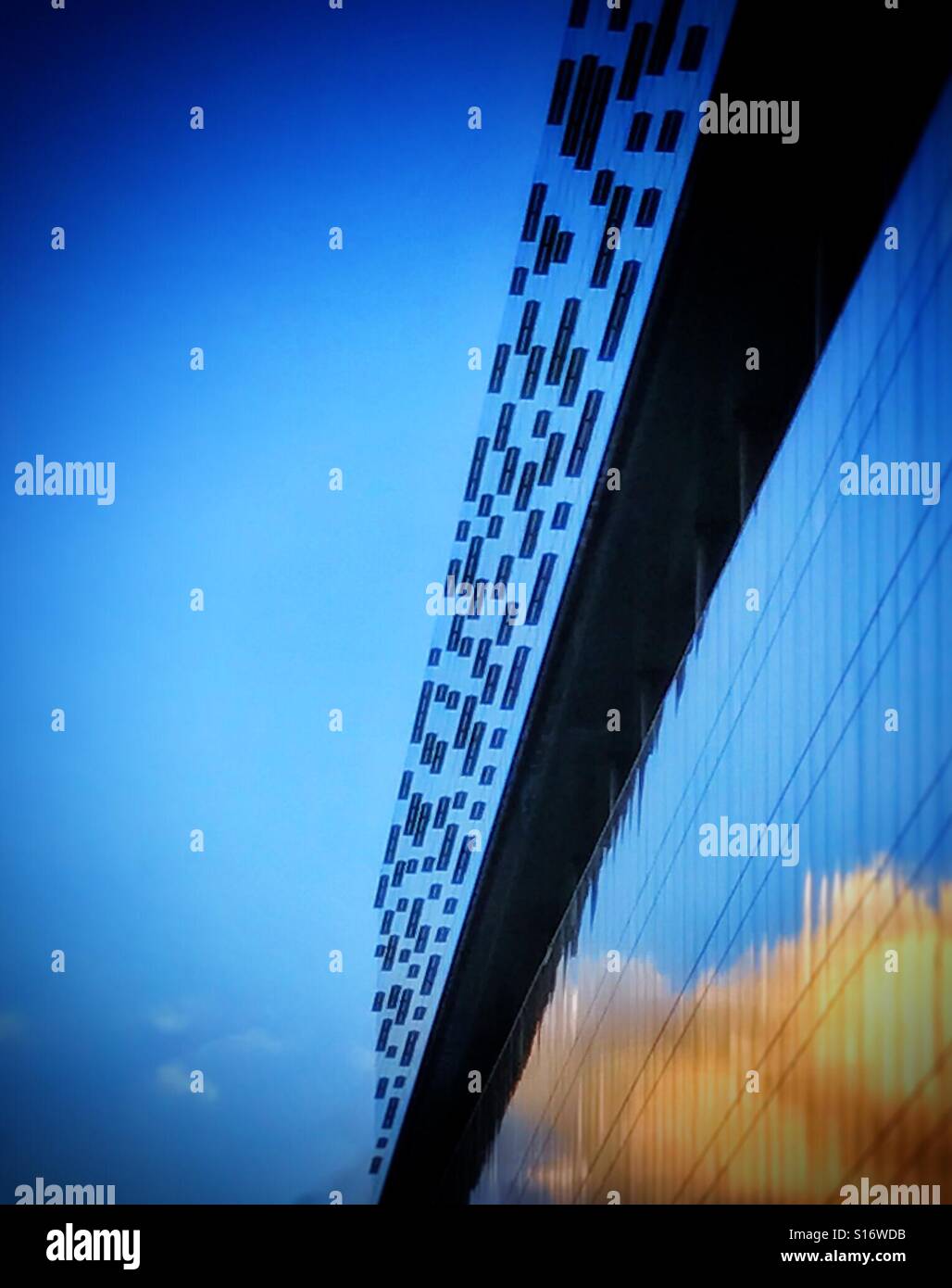 Refections of clouds set I a bright blue sky on the side of an office building in Southwark, south London - Smartphone Captured Stock Image