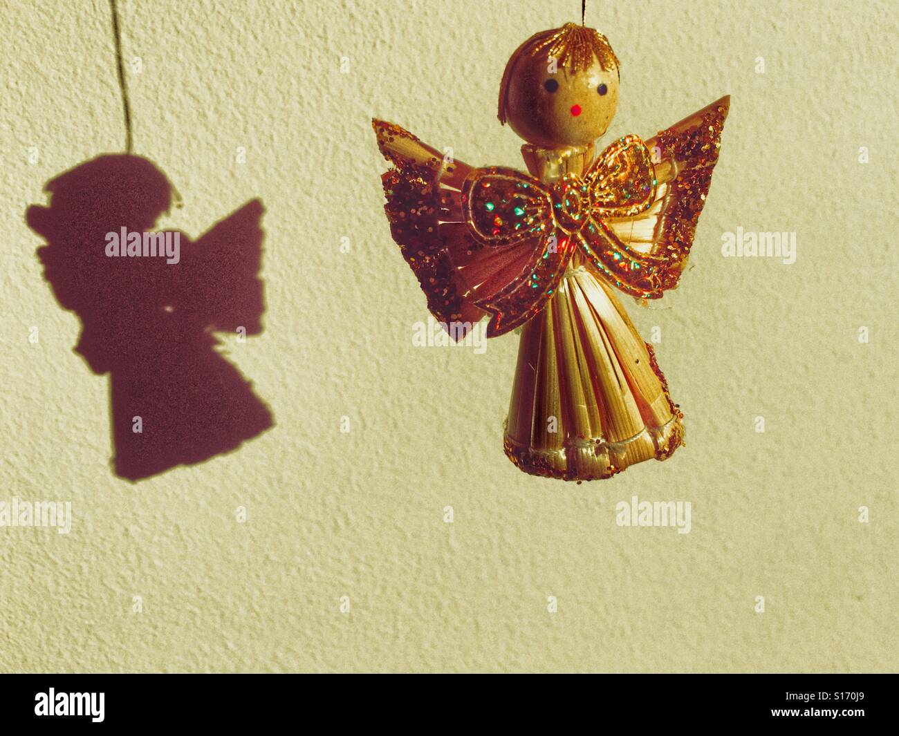 Christmas tree decoration. Handmade straw angel decorated with gold glitter. - Smartphone Captured Stock Image
