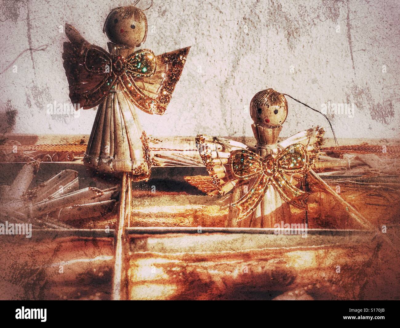 Box of handmade straw Christmas decorations, focus on two angels decorated with gold glitter - Smartphone Captured Stock Image