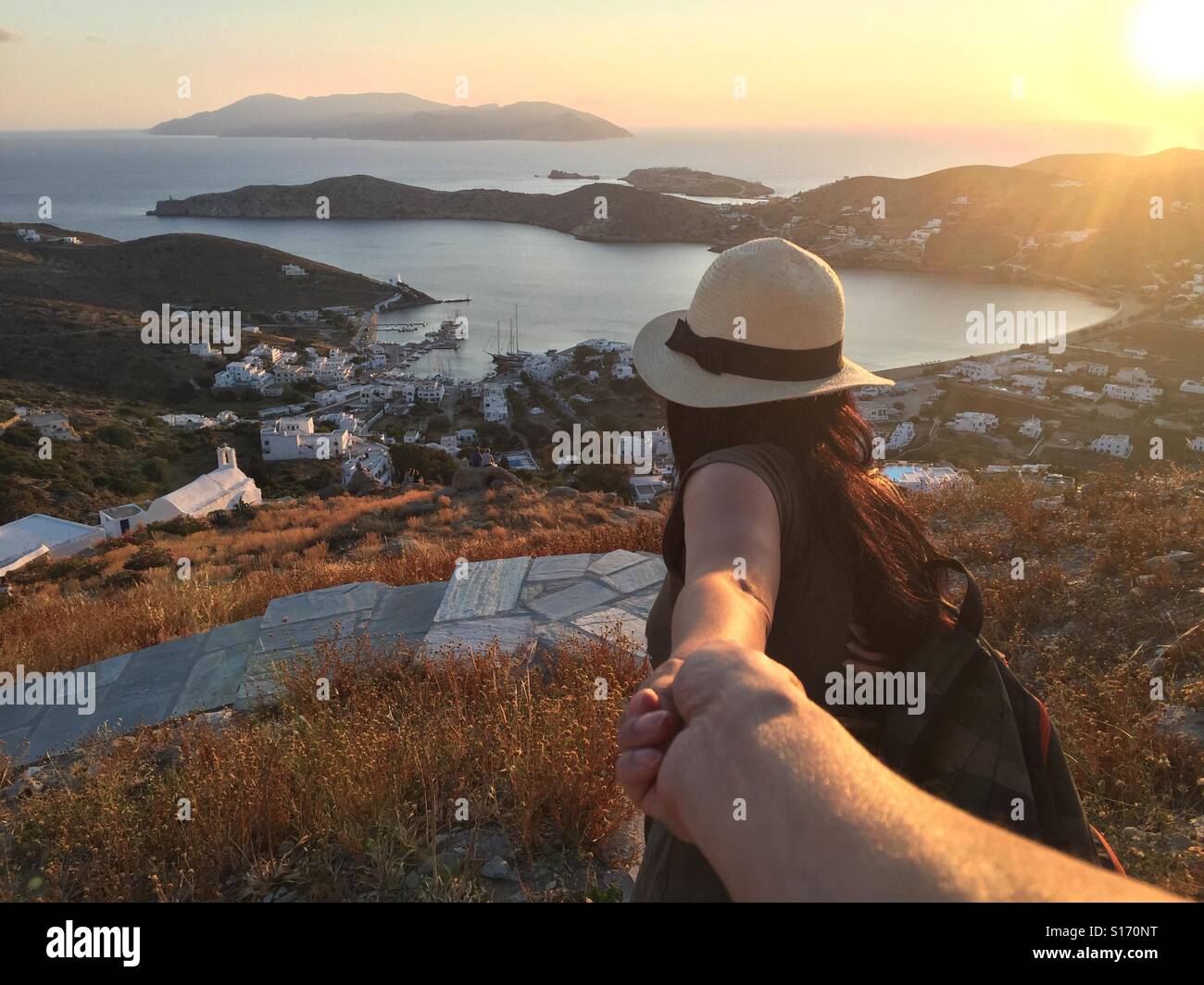 Follow me down the path to Chora, Ios, Greece as the sun sets on the Aegean  in the Cyclades Stock Photo - Alamy