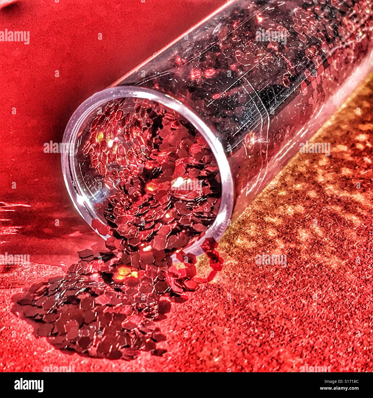 Clear plastic tube with red glitter spilling out - Smartphone Captured Stock Image