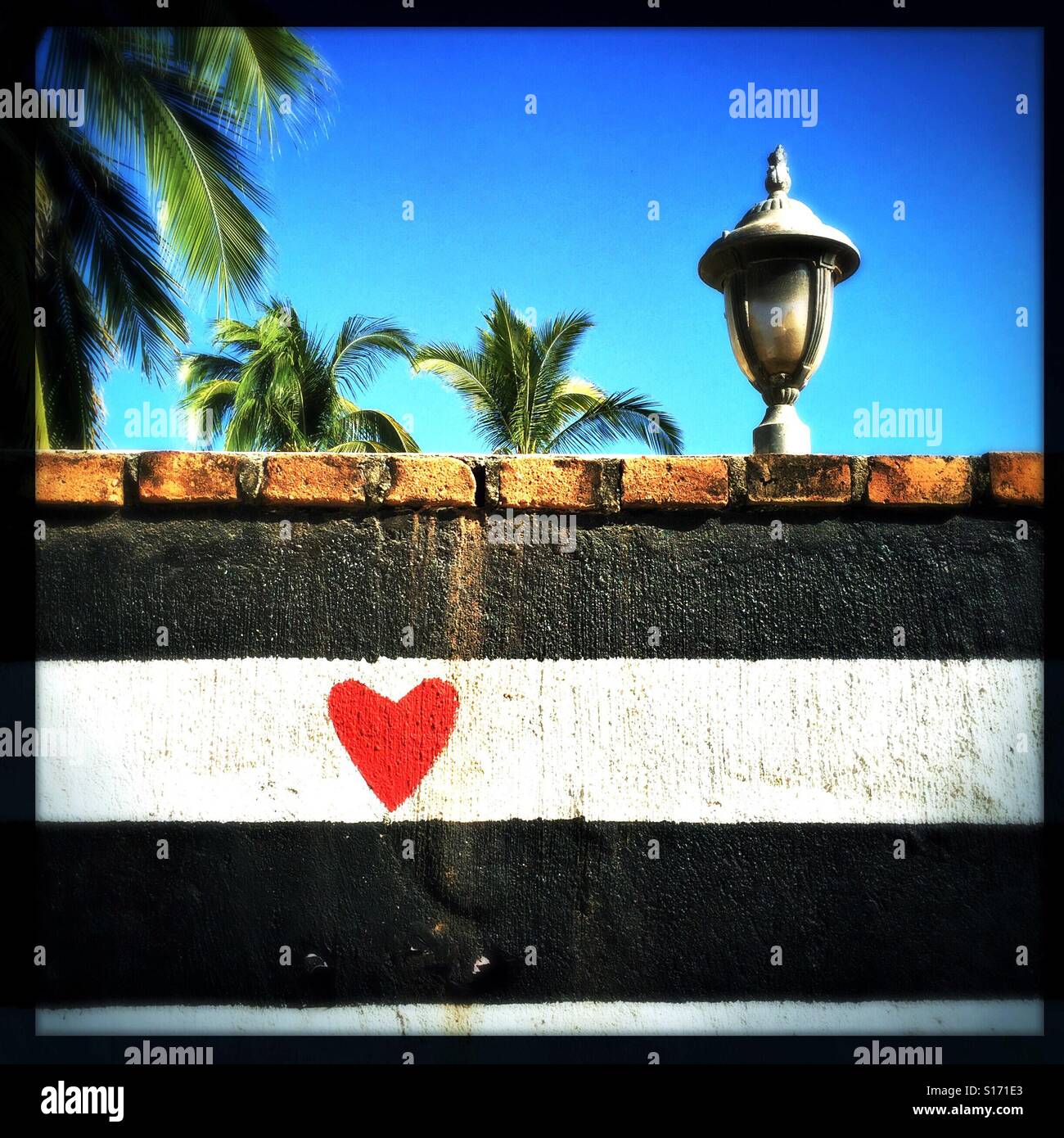 A red heart is painted on a wall as part of a mural near the beach in San Pancho, Nayarit, Mexico. Stock Photo