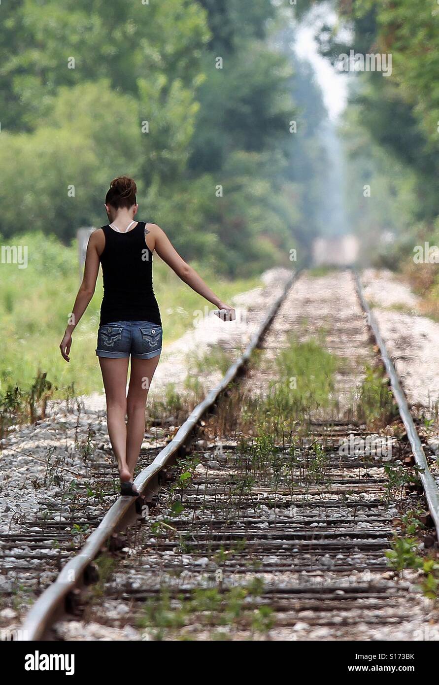 A girl walks seldom used railroad tracks Stock Photo Alamy