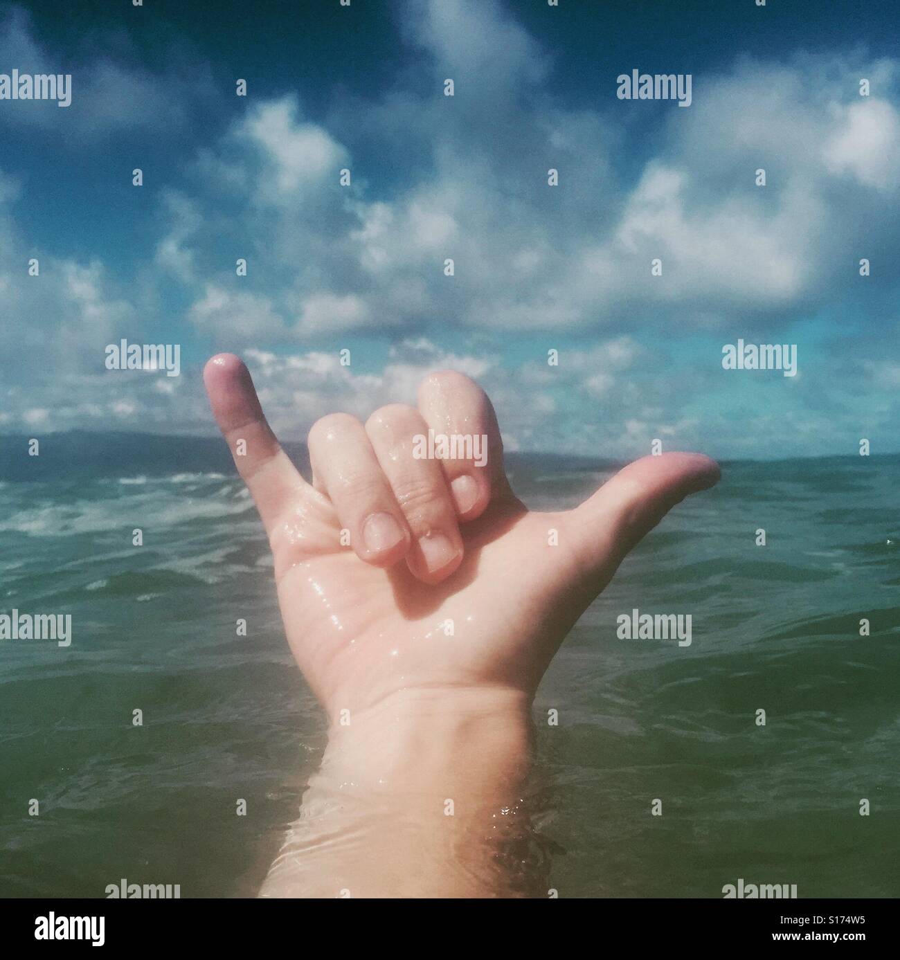 A right hand giving the Shaka sign.  The shaka sign, sometimes known as 'hang loose', is a gesture of friendly intent often associated with Hawaii and surf culture. Maui, Hawaii, USA. Stock Photo