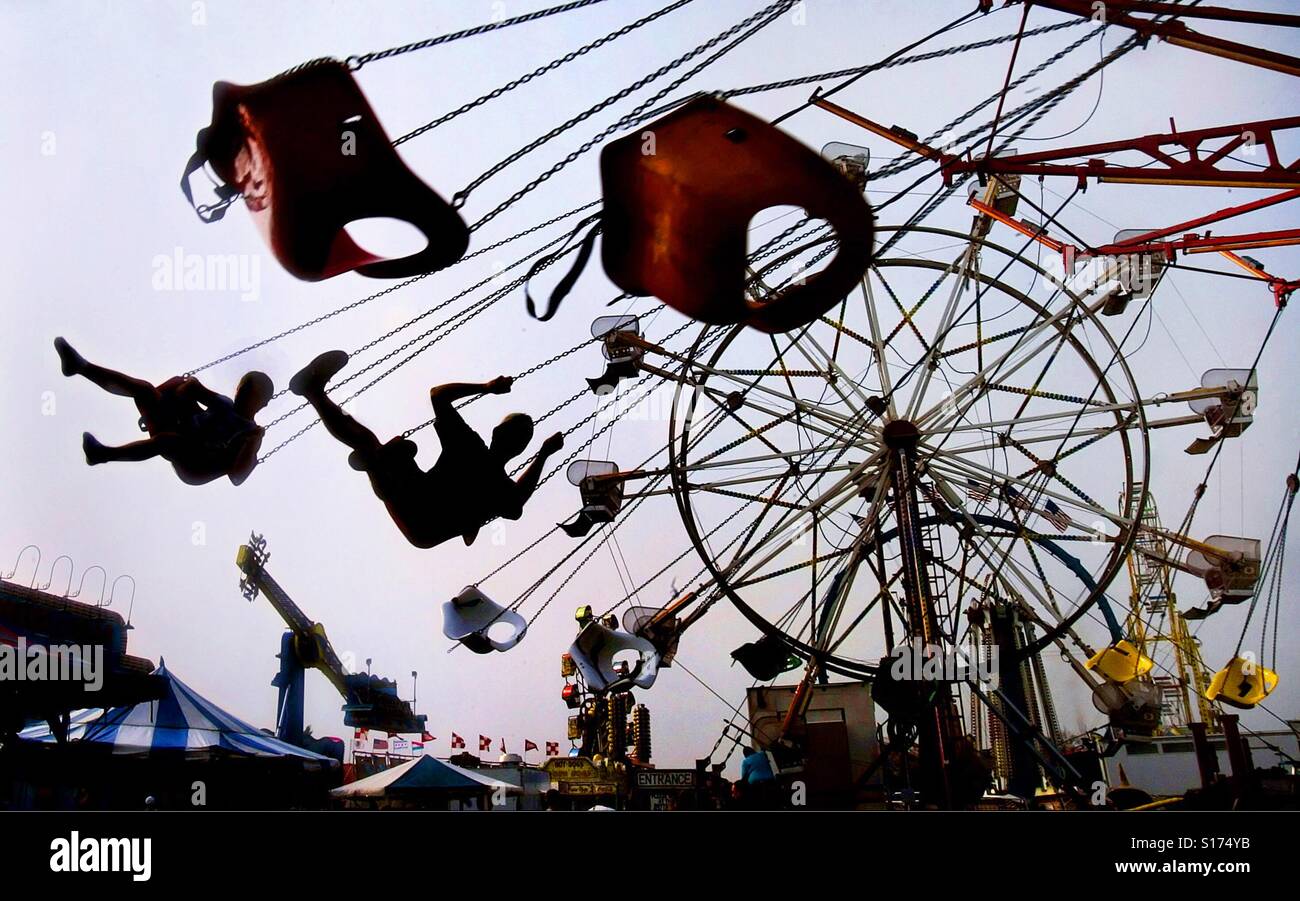 Riders are seen on a carnival ride at a fair - Smartphone Captured Stock Image
