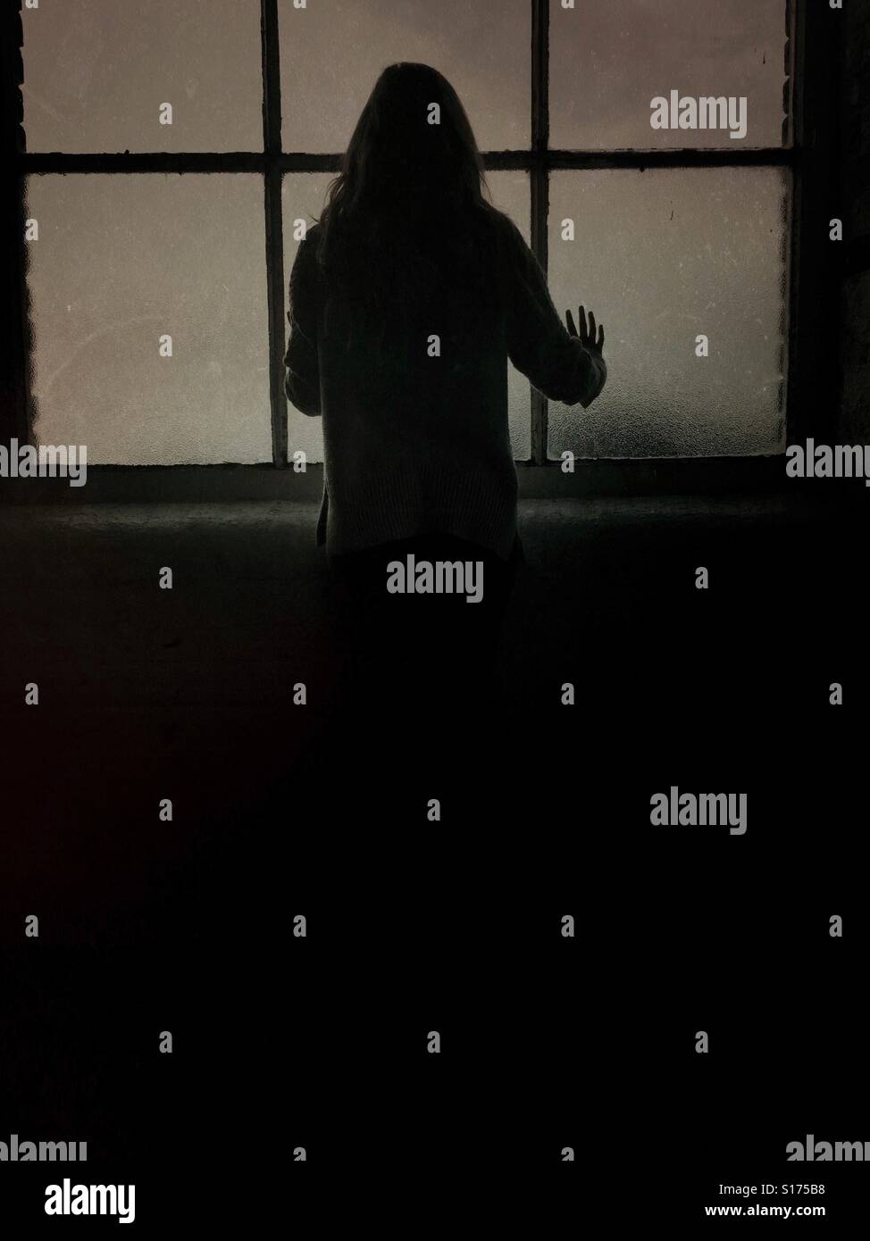 Silhouette of a woman standing by the window - Smartphone Captured Stock Image