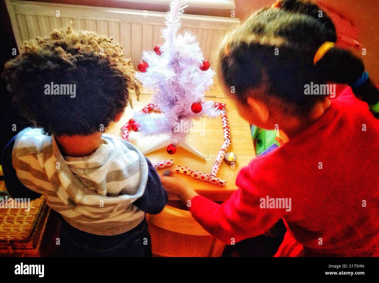 Children decorating their Christmas tree. - Smartphone Captured Stock Image