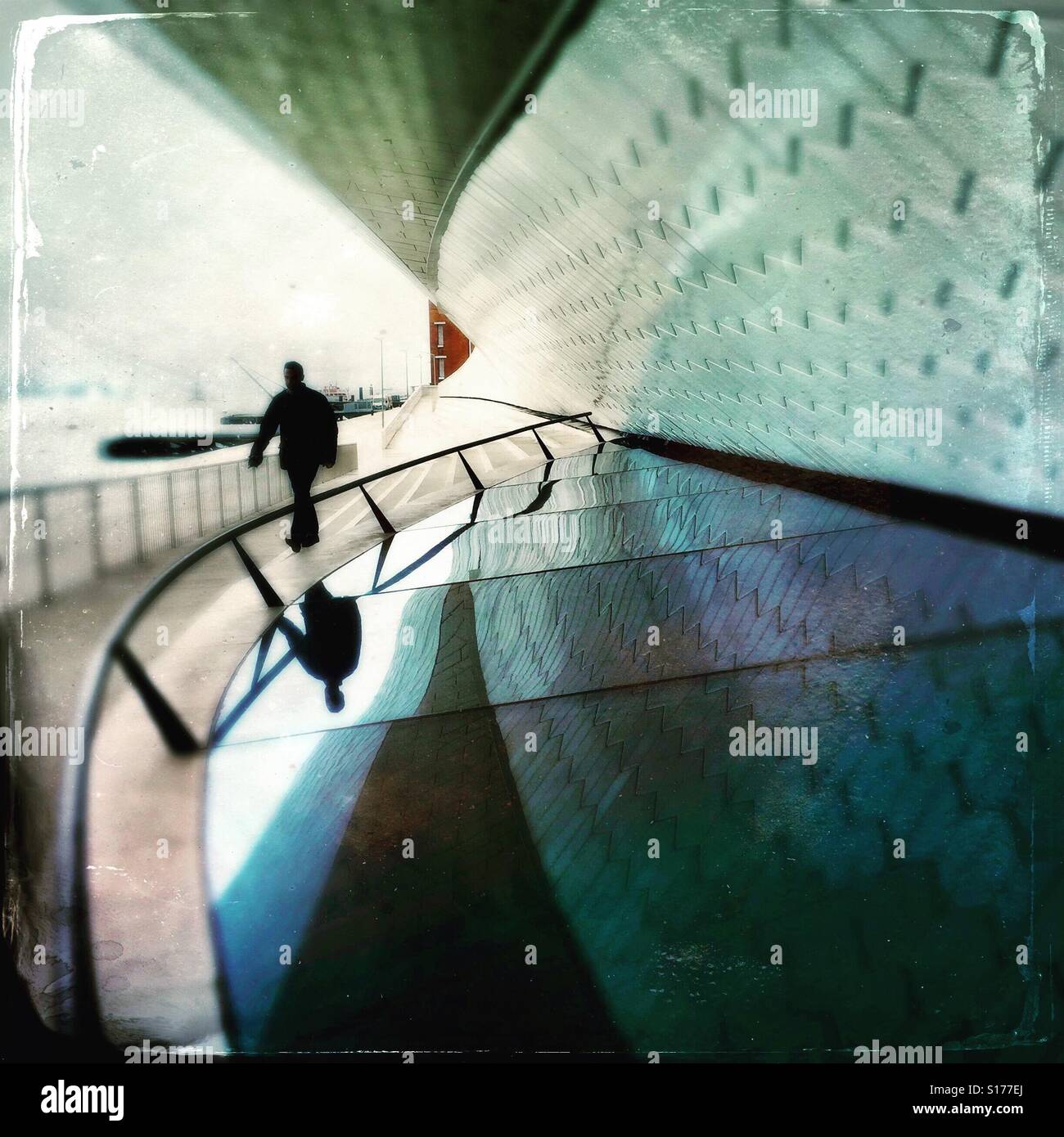 Man and his reflection walking by a modern facade - Smartphone Captured Stock Image