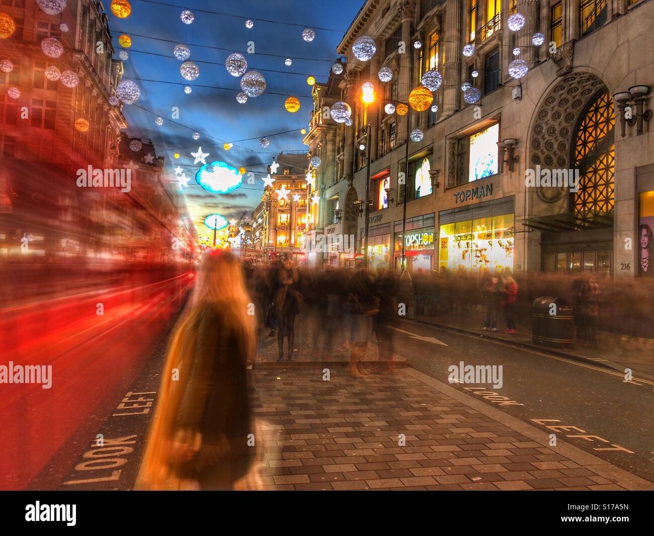 London red bus and Oxford street at Christmas. People & traffic rendered as motion blur by Slow Shutter App on iPhone. 3-12-16. Stock Photo