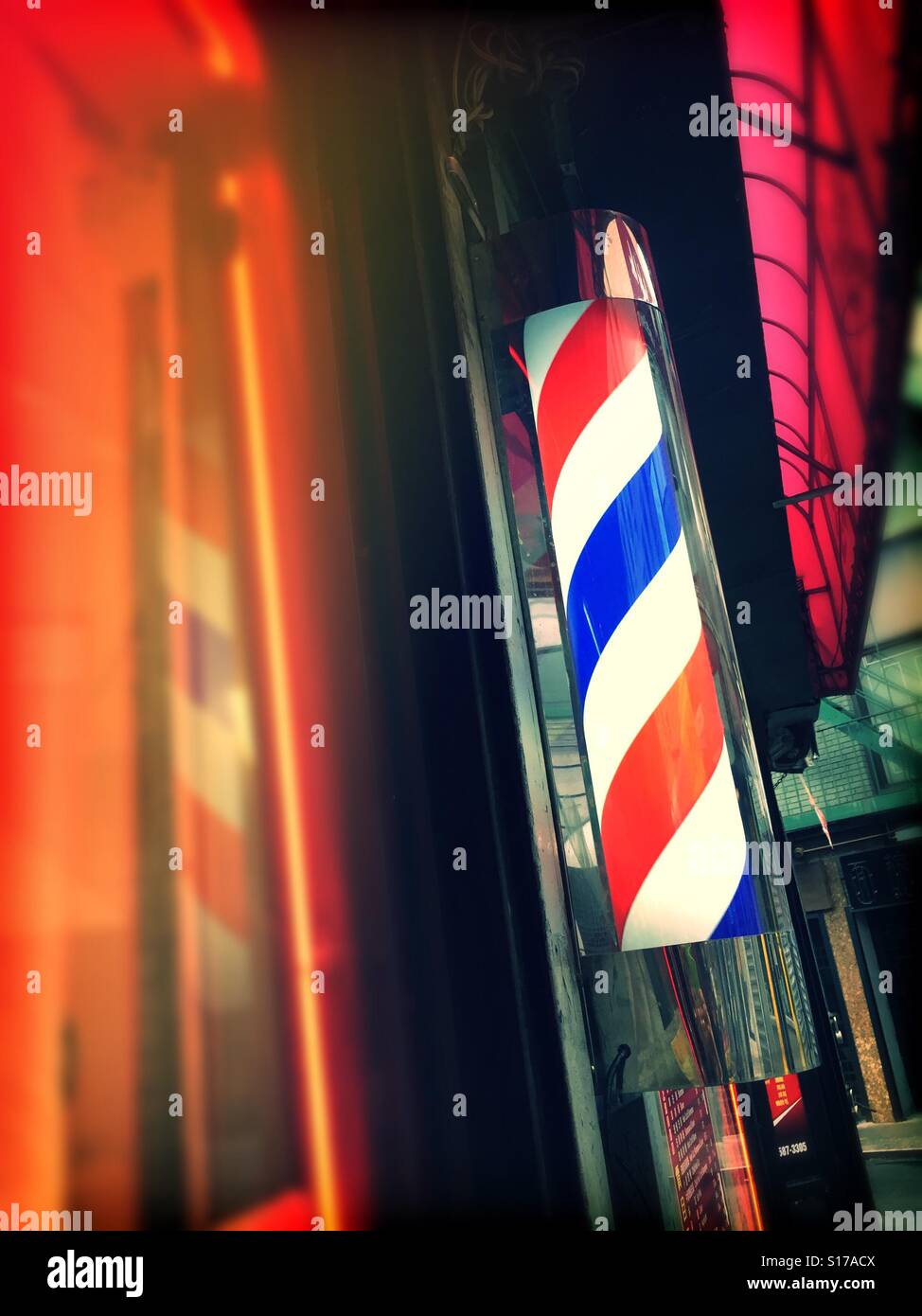 An old fashioned rotating red white and blue Barbershop pole - Smartphone Captured Stock Image
