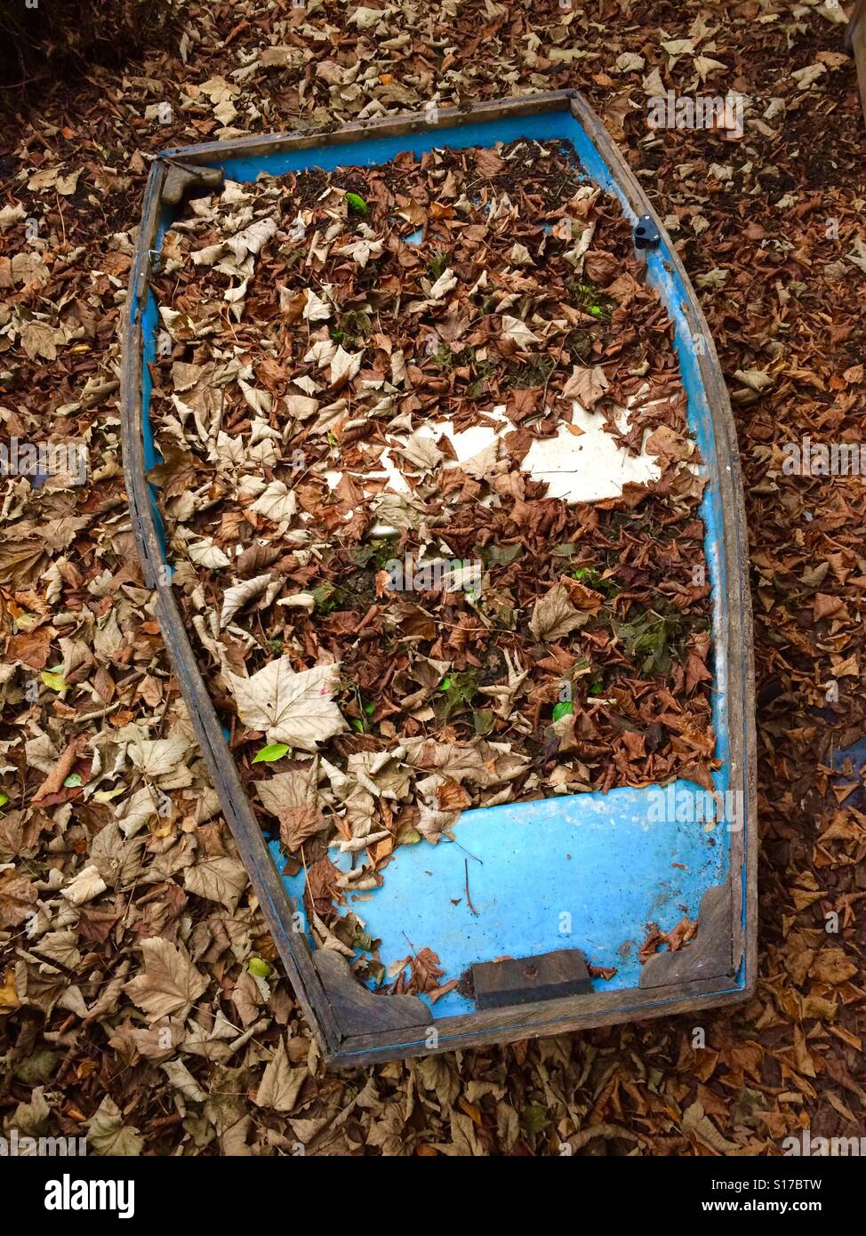 Boat covered in leaves Stock Photo
