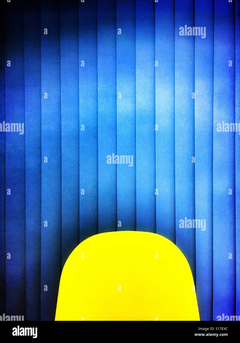 Abstract of yellow chair back against blue blinds - Smartphone Captured Stock Image