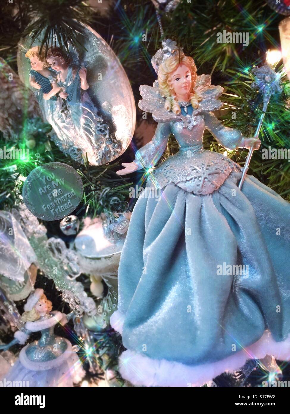 A beautiful princess in a blue gown is a Christmas ornament on a brightly  lit Christmas tree Stock Photo - Alamy