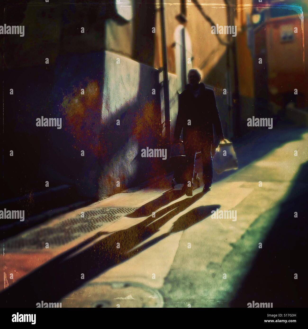 Shadows playing as a man walks down a street in France - Smartphone Captured Stock Image