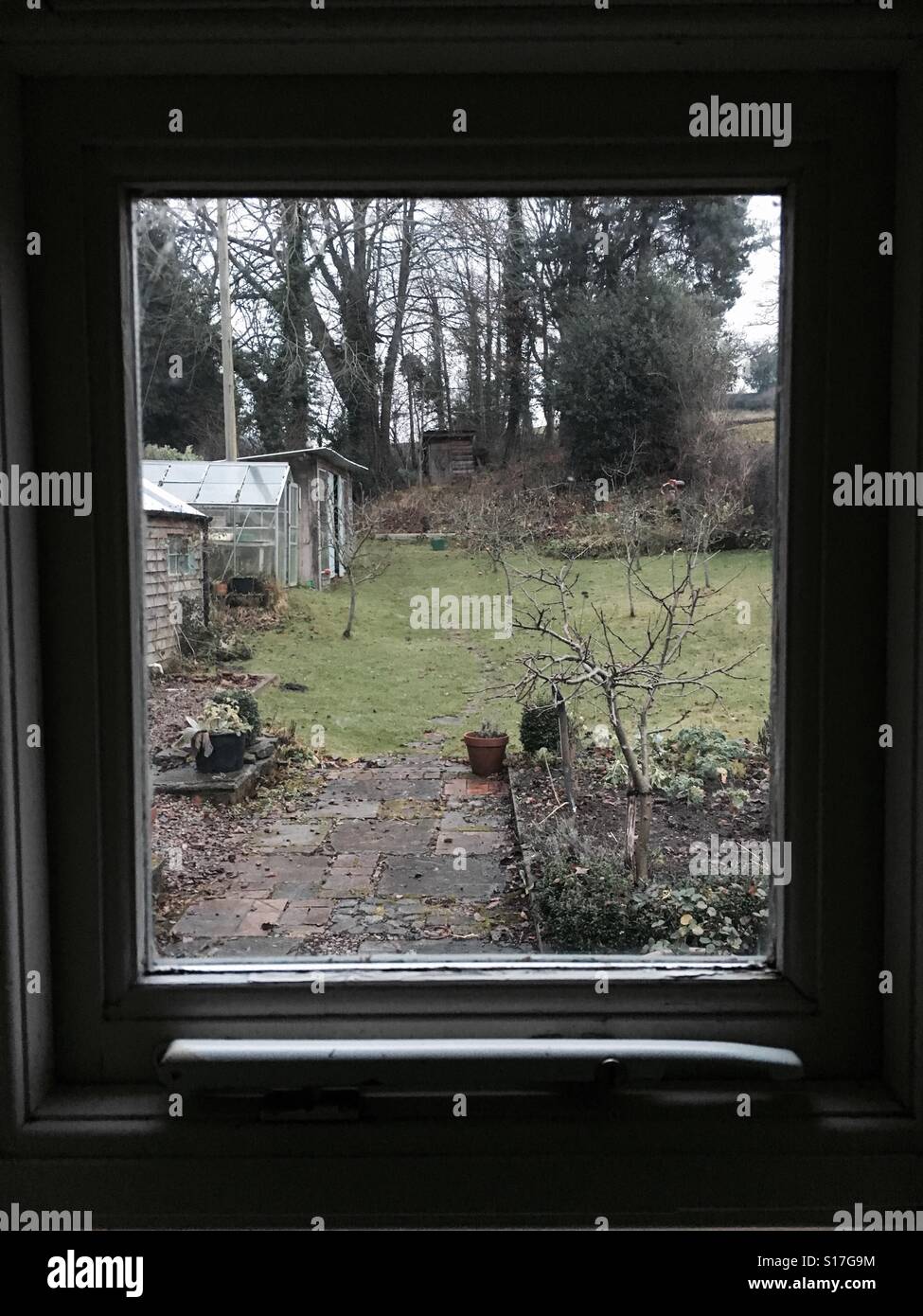 The garden in winter viewed through a cottage window - Smartphone Captured Stock Image
