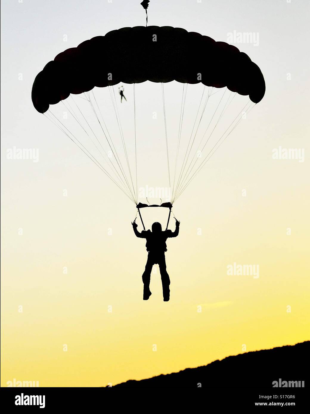 Silhouette of a skydiver at night Stock Photo