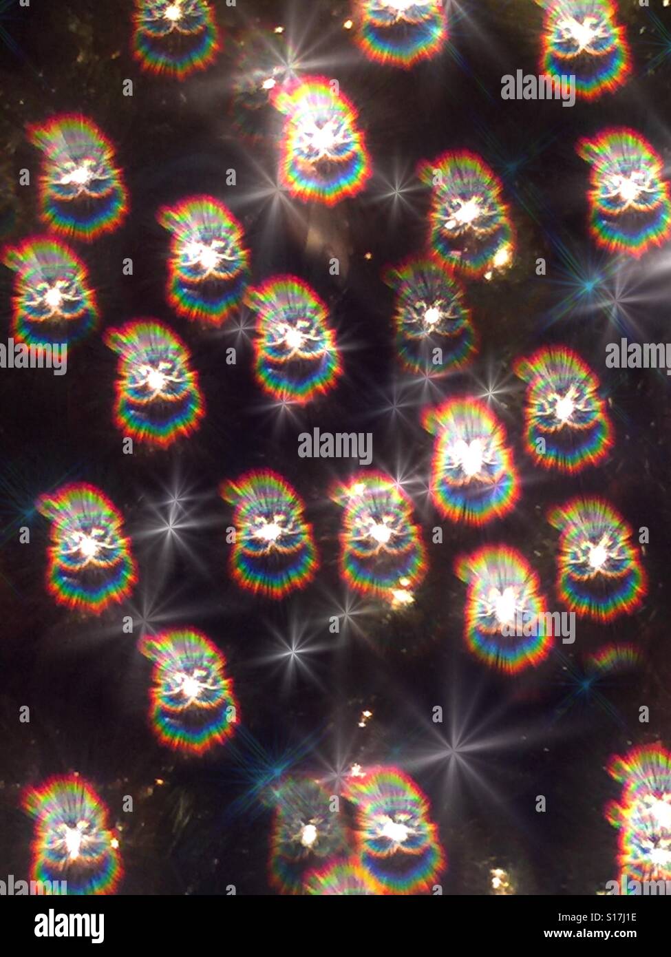 Bright holographic prismatic lights of Santa Claus heads on a Christmas tree Stock Photo