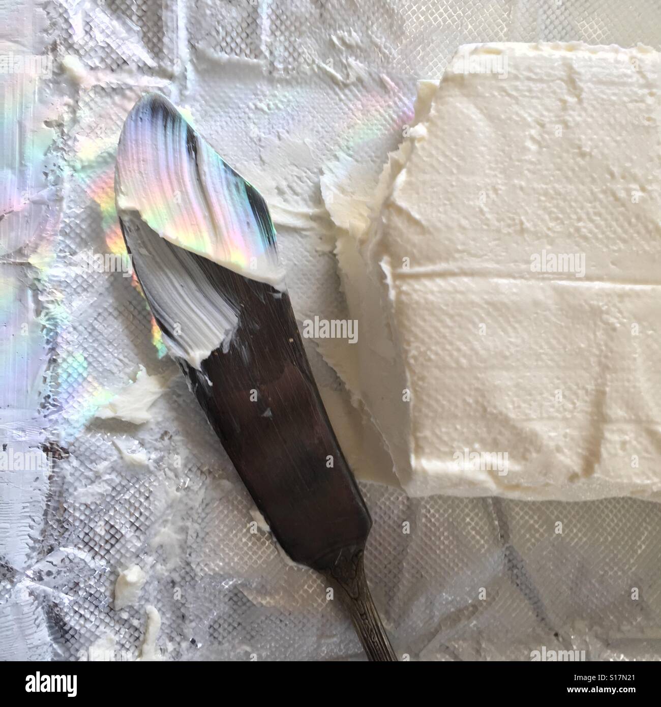 Cream cheese in wrapper with spreader knife Stock Photo Alamy