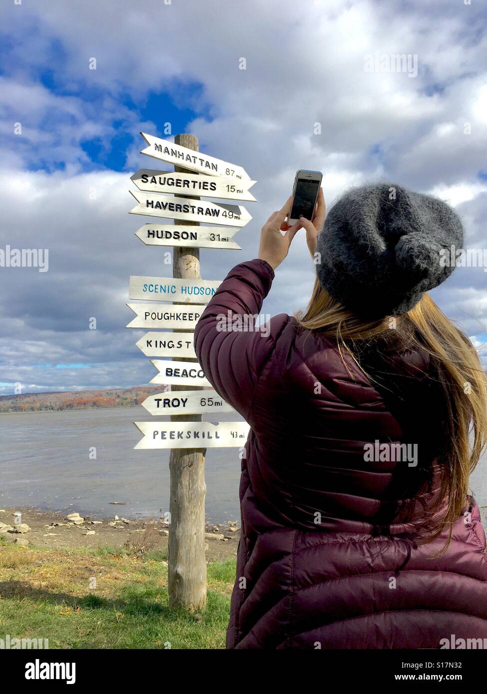 Woman shooting a photo on her iPhone of sign at park - Smartphone Captured Stock Image
