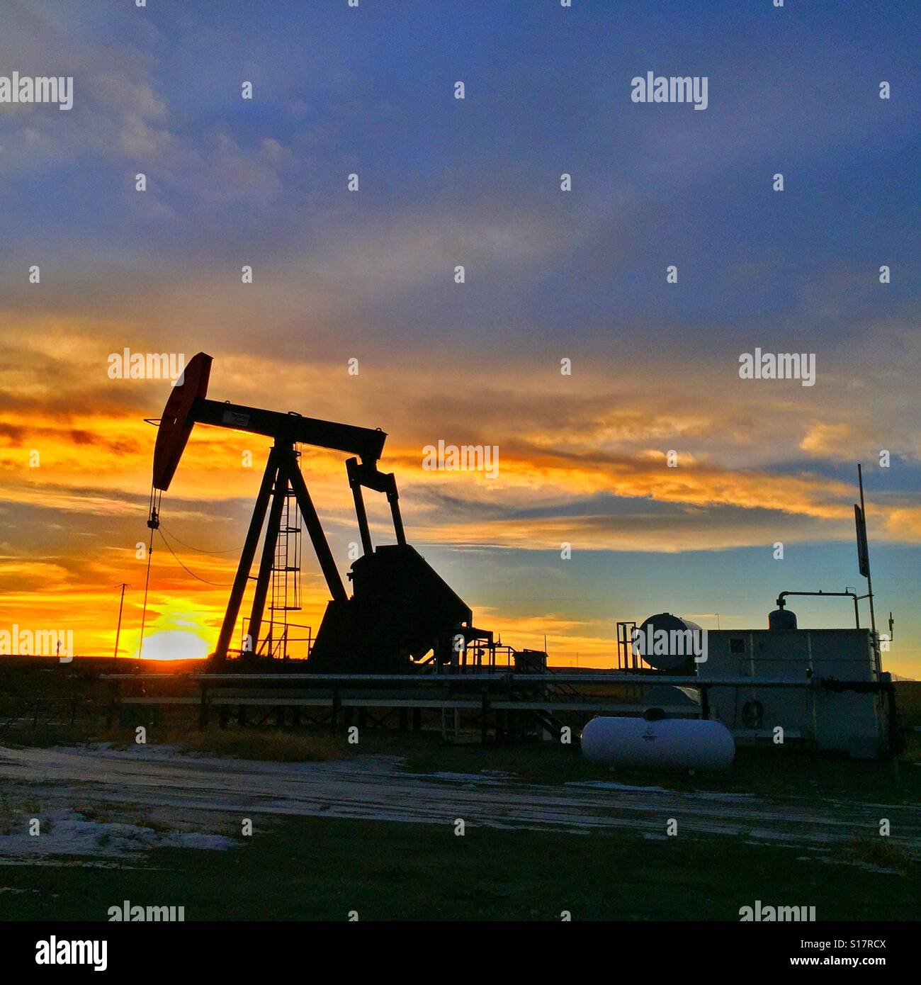 Oil well pump jack silhouette at sunset - Smartphone Captured Stock Image