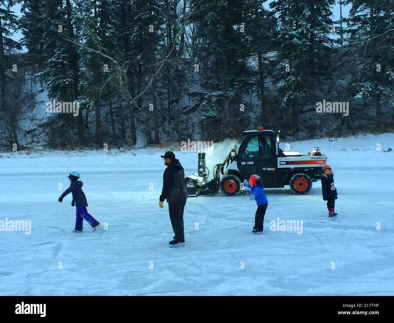 Family skating and snow clearing machine - Smartphone Captured Stock Image