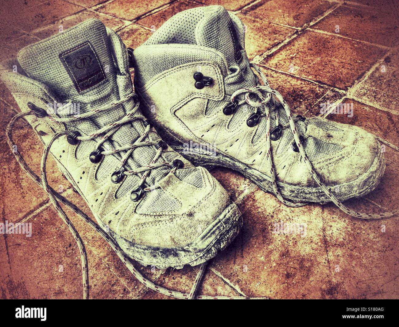 Muddy hiking boots on a tiled floor - Smartphone Captured Stock Image
