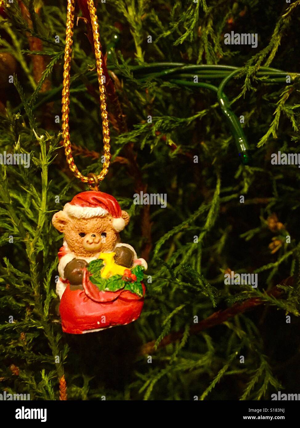 Christmas Ornament of a Santa dressed bear hanging from tree Stock Photo