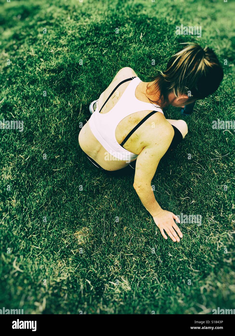 Woman resting after exercising in the park - Smartphone Captured Stock Image