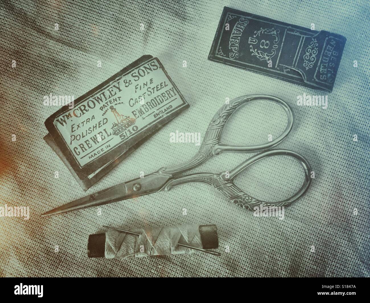 Antique sewing kit : packets of needles, scissors, needle and thread - Smartphone Captured Stock Image