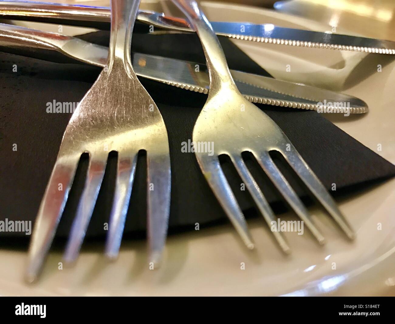 Two forks on a dish. Close view. Stock Photo
