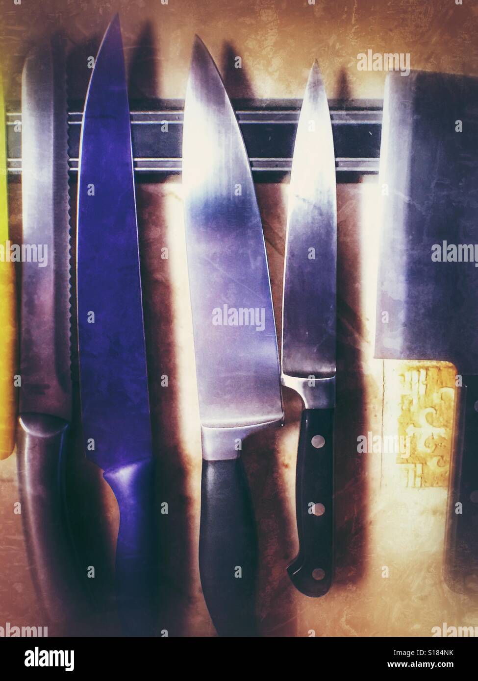 https://c8.alamy.com/comp/S184NK/row-of-knives-hanging-on-a-magnetic-strip-in-a-kitchen-S184NK.jpg