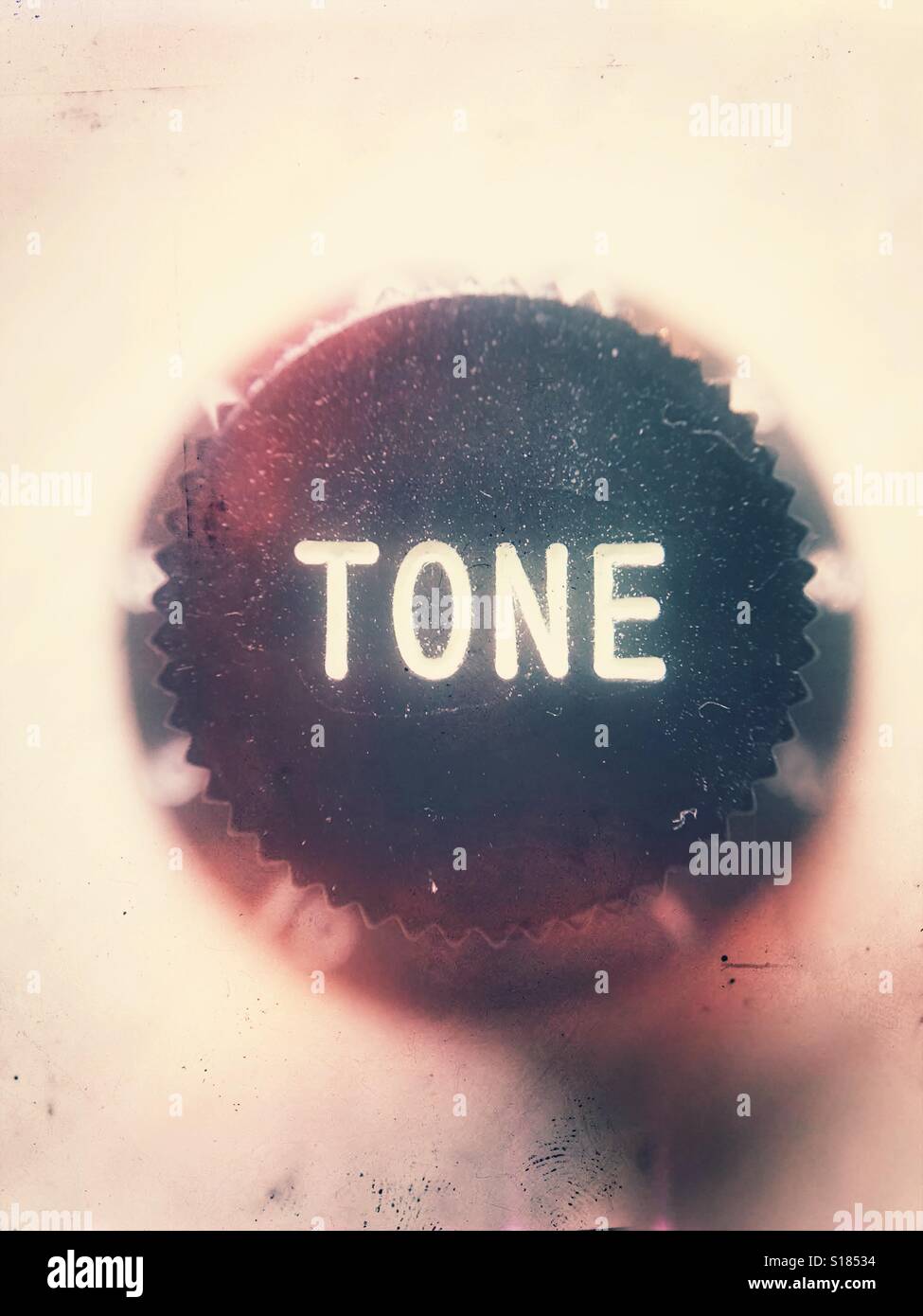 Black plastic knob with the word 'tone' imprinted in white - Smartphone Captured Stock Image