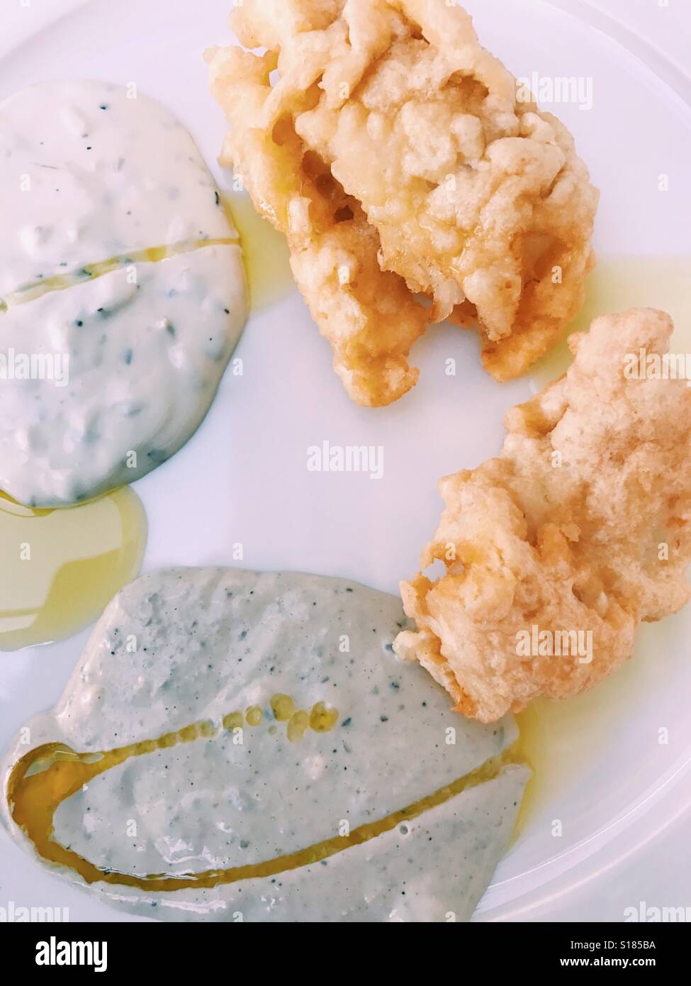 Cod fish in tempura with tartare sauce on plate Stock Photo