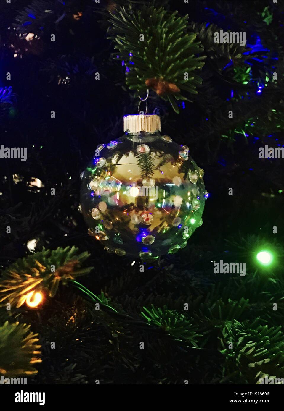 Shiny Iridescent Glass Ornament On Lighted Christmas Tree Shiny Iridescent Glass Ornament On Lighted Christmas Tree