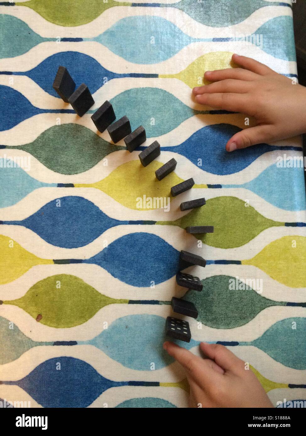 Dominoes and child's hand - Smartphone Captured Stock Image