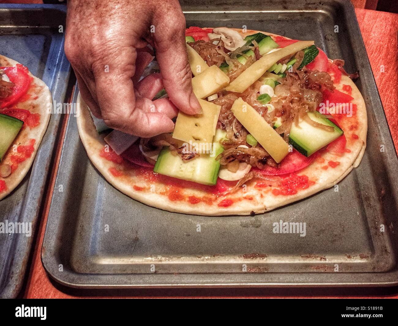 Putting the cheese on an uncooked pizza - Smartphone Captured Stock Image