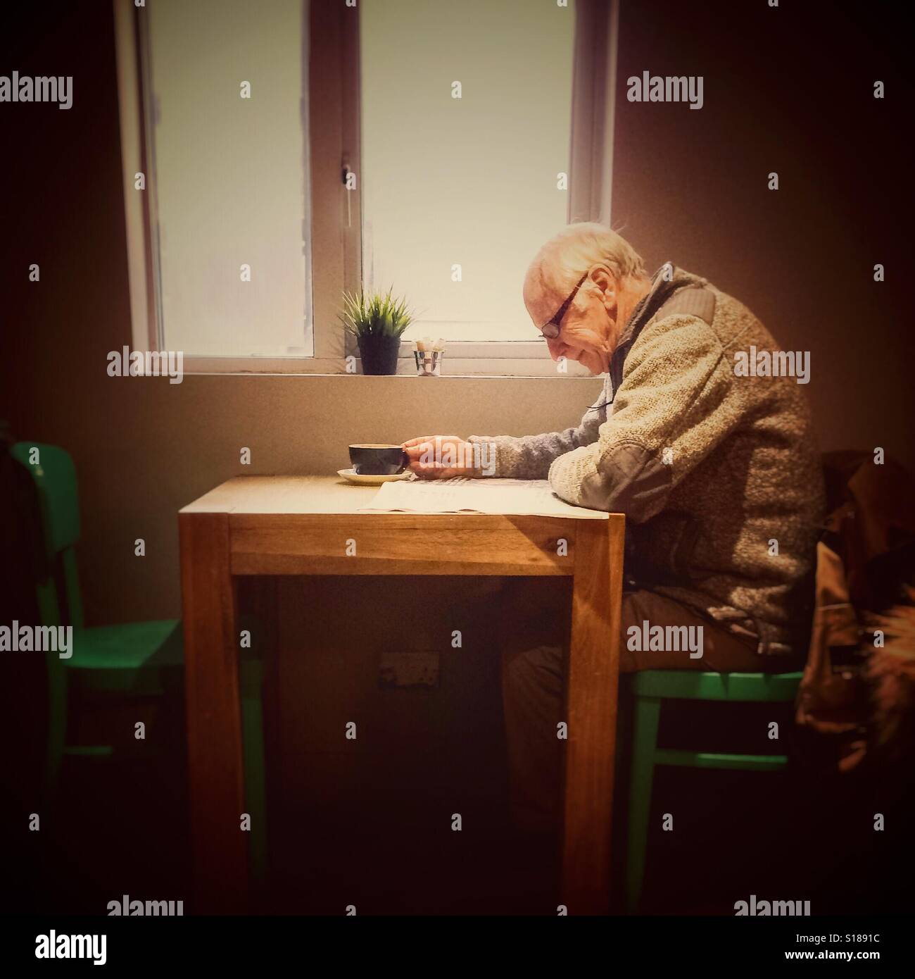 Lone diner reading in a cafe - Smartphone Captured Stock Image