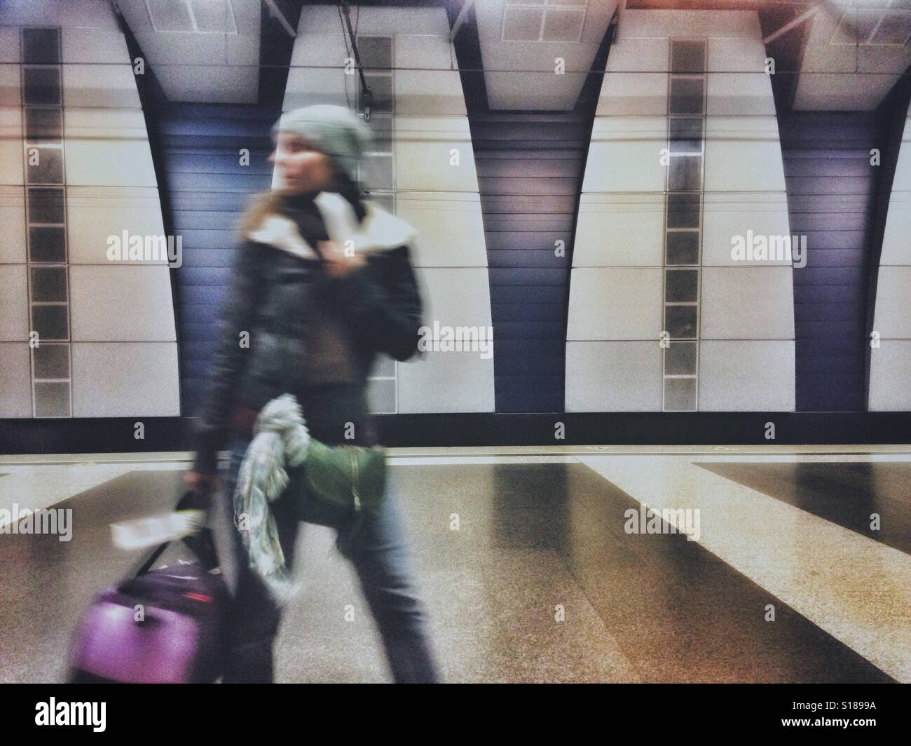 Moving blur of a walking person on a platform with a luggage bag - Smartphone Captured Stock Image