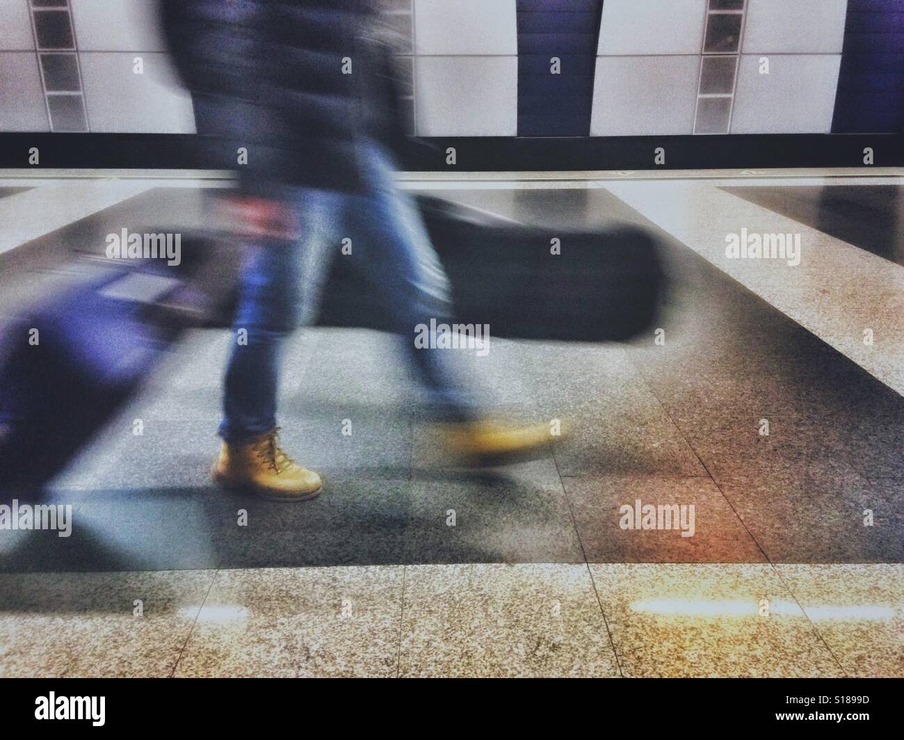 Moving blur of a person walking with suitcases - Smartphone Captured Stock Image